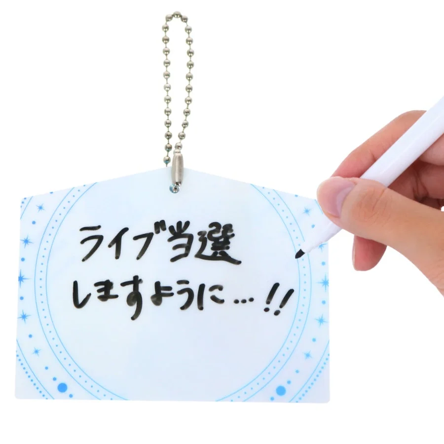 アクリル絵馬に願い事を書き込む様子