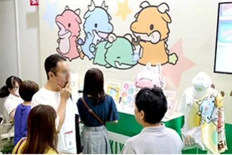 かわいいドラゴン風キャラクターのグッズが展示されているイベント会場の様子